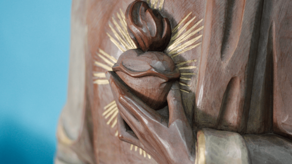 Sacred Heart of Jesus statue with fiery flames, showcasing divine compassion.