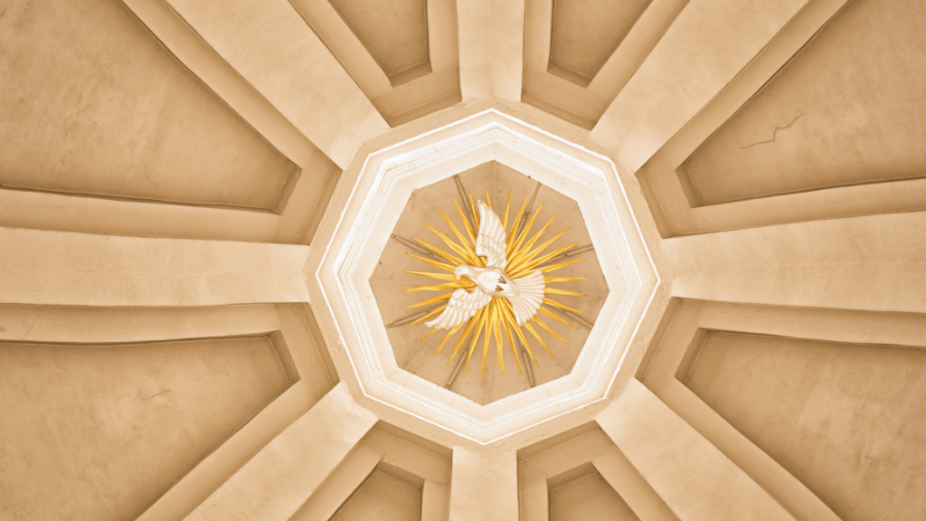 Dove with golden rays in a church ceiling, symbolizing the Holy Spirit.

