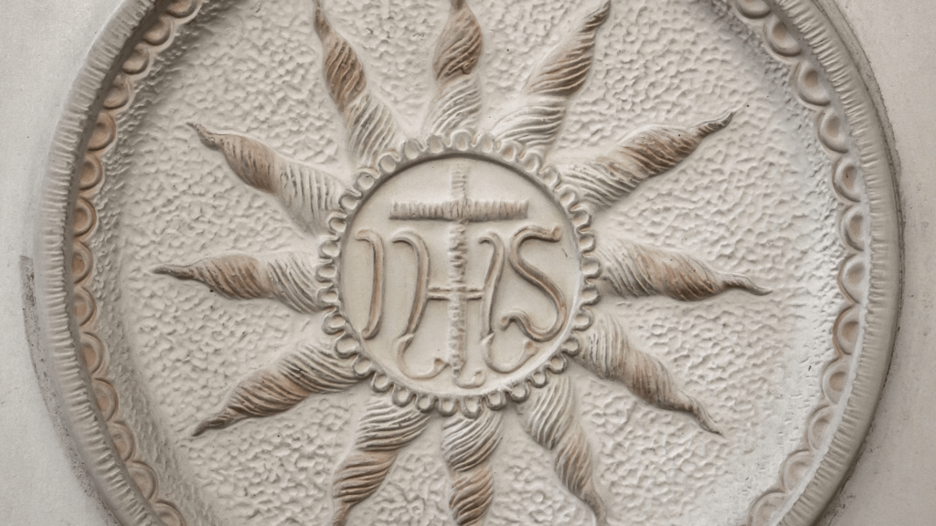 IHS symbol with a sunburst in stone relief.

